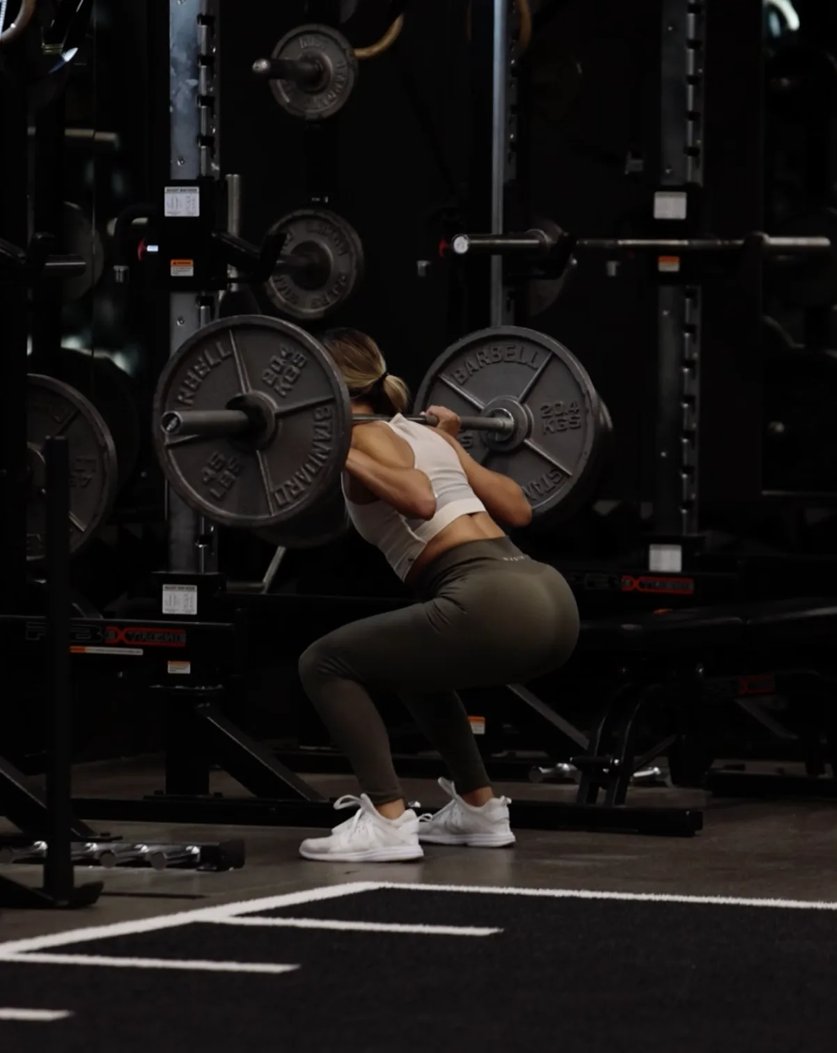 Trainer spotting a member through a one-on-one lifting session