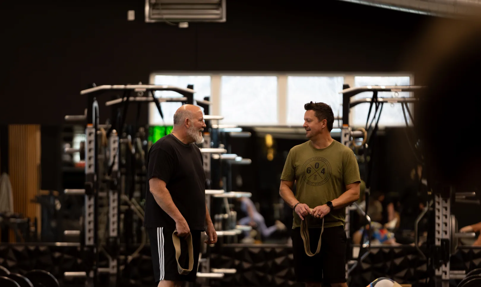 Coach guiding a member through a slower paced strength movement