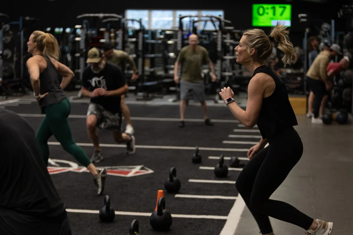 Members lifting barbells together during a group class on the turf floor at The Pitt